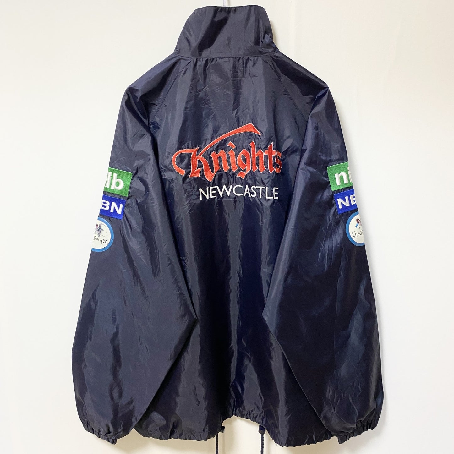 古着 used　NRL　ニューカッスルナイツ　長袖ナイロンジャケット　ロゴ刺繍アウター　バックデザイン　ネイビー　Mサイズ