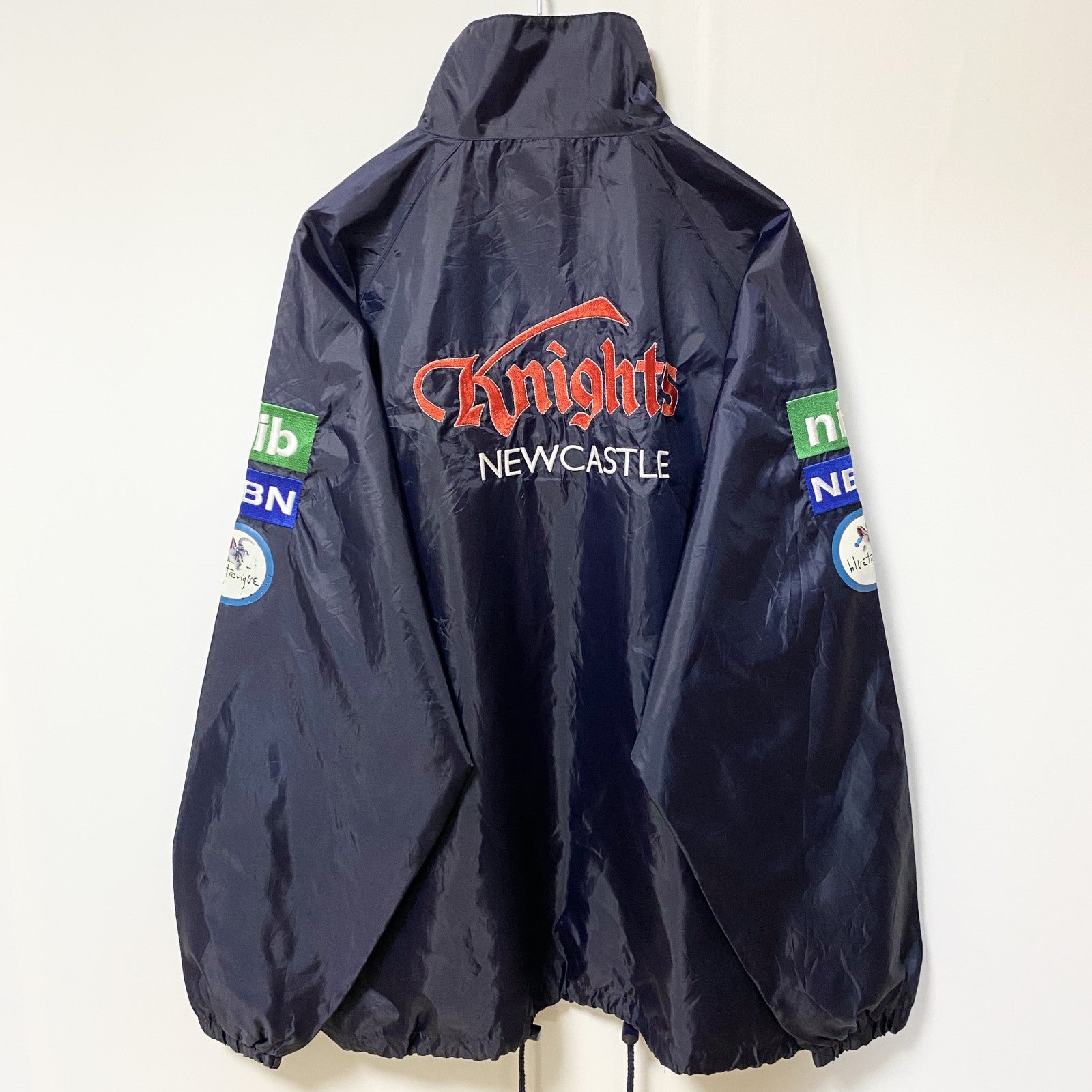 古着 used　NRL　ニューカッスルナイツ　長袖ナイロンジャケット　ロゴ刺繍アウター　バックデザイン　ネイビー　Mサイズ